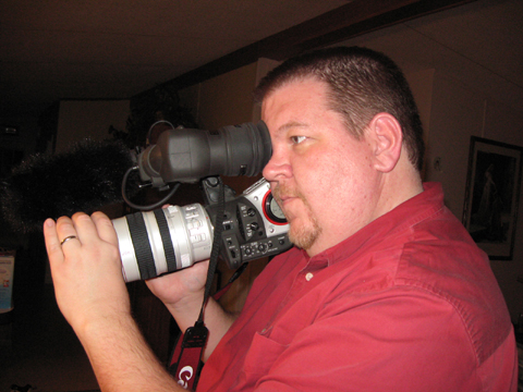 Nathan Stout filming with a video camera for the fort worth public access television show according to whim